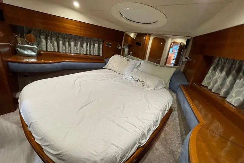  Yacht Photos Pics Luxurious bedroom interior of a 2006 Princess 50 yacht with elegant wood finishes.