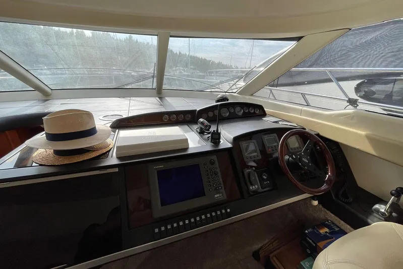  Yacht Photos Pics Helm of 2006 Princess 50 yacht with navigation controls and a hat on the dashboard.