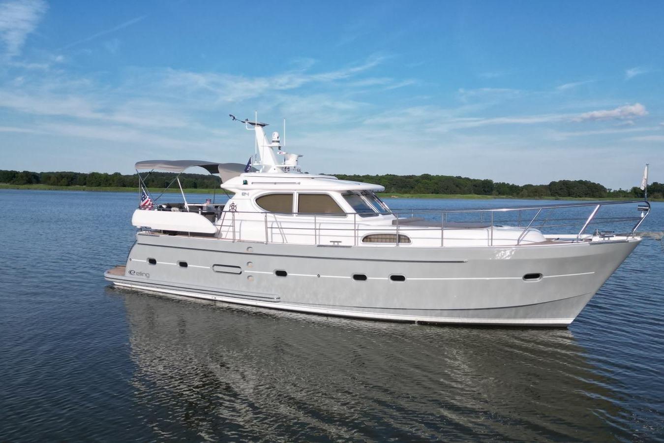 2024 Elling E4 yacht cruising on a serene lake under a clear blue sky.