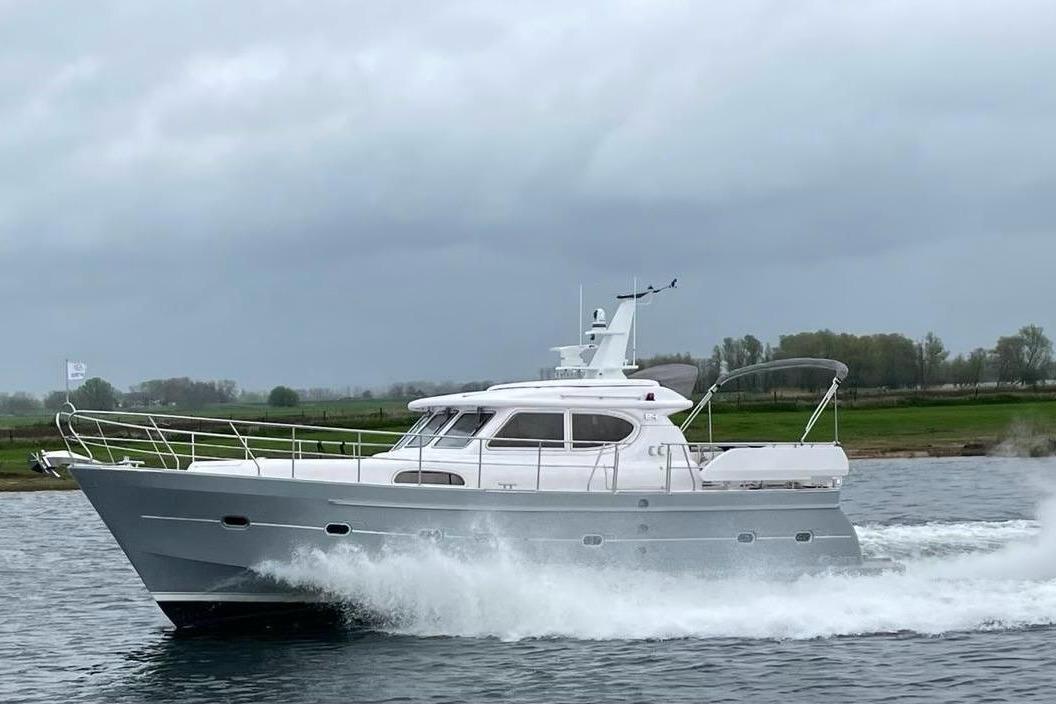 2024 Elling E4 yacht cruising on a river under cloudy skies.