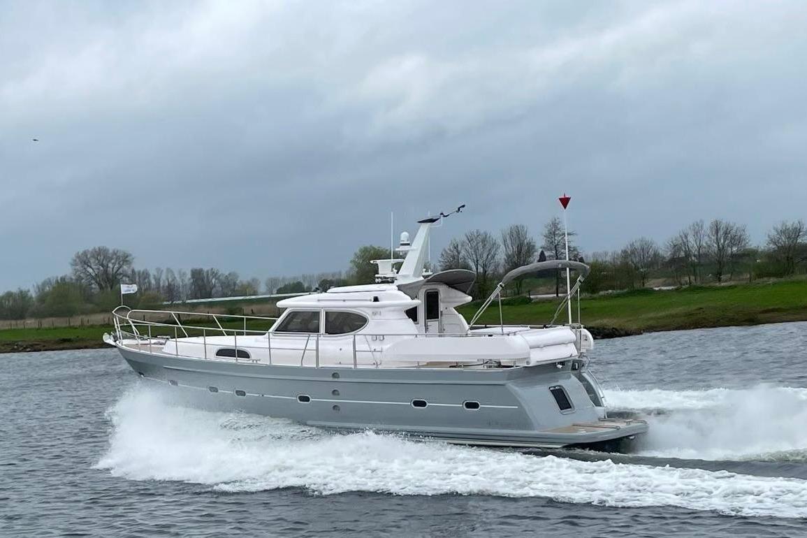 2024 Elling E4 yacht cruising on a river with lush green banks.