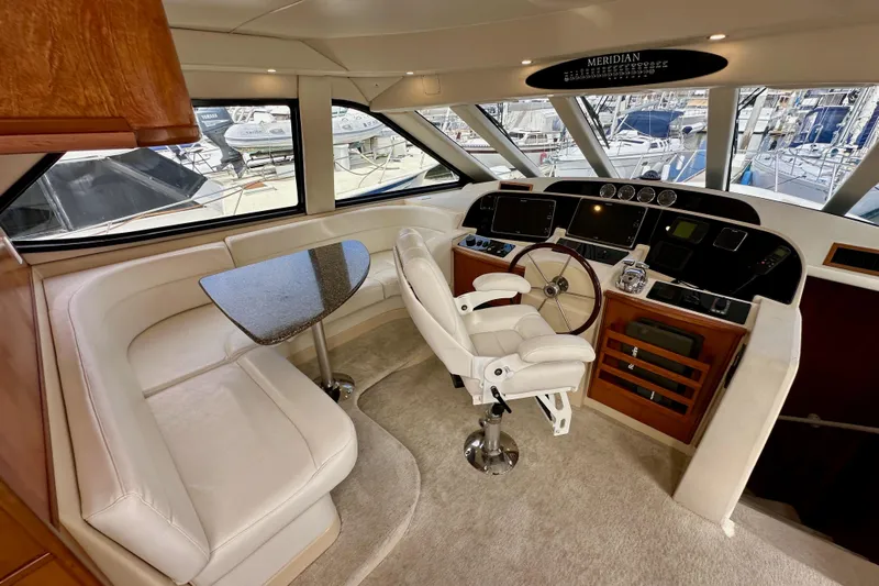 Seas The Day Yacht Photos Pics Luxurious 2004 Meridian 580 Pilothouse interior with helm, seating, and panoramic windows.