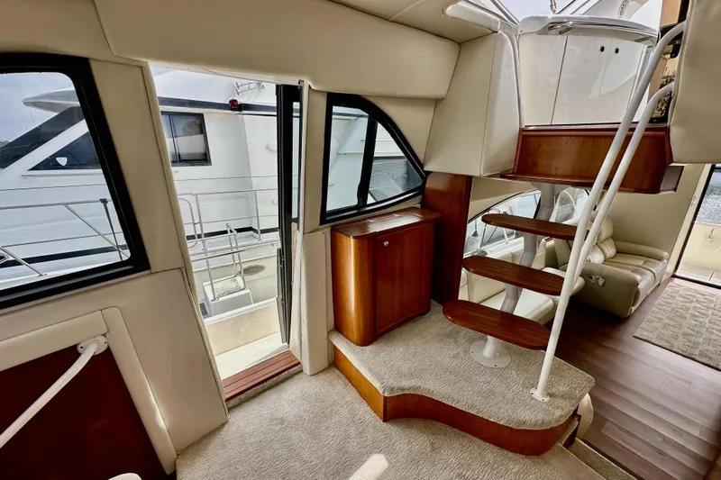 Seas The Day Yacht Photos Pics Interior of 2004 Meridian 580 Pilothouse yacht with elegant wooden staircase and plush seating.