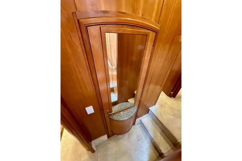 Seas The Day Yacht Photos Pics Wooden interior of 2004 Meridian 580 Pilothouse yacht with mirrored door and carpeted stairs.