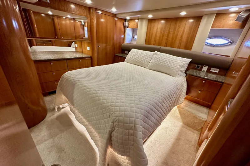 Seas The Day Yacht Photos Pics Luxurious bedroom interior of 2004 Meridian 580 Pilothouse yacht with wood paneling and cozy bedding.
