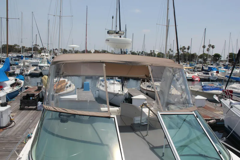 My Jojo Yacht Photos Pics 2005 Cruisers Yachts 370 Express docked in a marina, surrounded by sailboats.