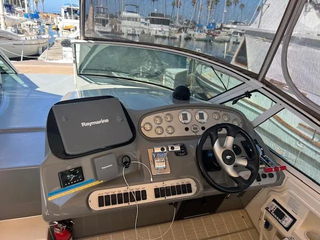 My Jojo Yacht Photos Pics 2005 Cruisers Yachts 370 Express helm with navigation equipment and steering wheel at marina.
