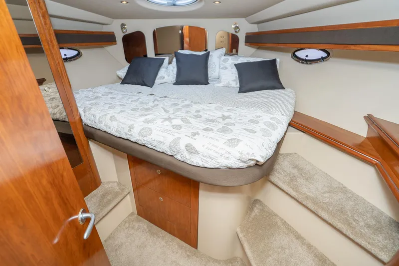 My Jojo Yacht Photos Pics Luxurious cabin interior of 2005 Cruisers Yachts 370 Express with cozy bedding and elegant wood finishes.