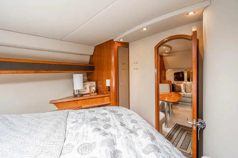 My Jojo Yacht Photos Pics Luxurious interior of 2005 Cruisers Yachts 370 Express, featuring cozy bedroom and elegant wood finishes.