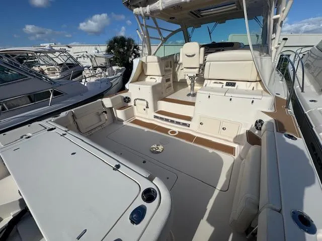  Yacht Photos Pics 2021 Grady-White Express 370 boat interior with seating and helm, docked under blue sky.