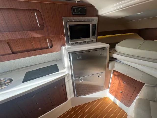  Yacht Photos Pics 2021 Grady-White Express 370 interior with kitchenette, microwave, and wood accents.