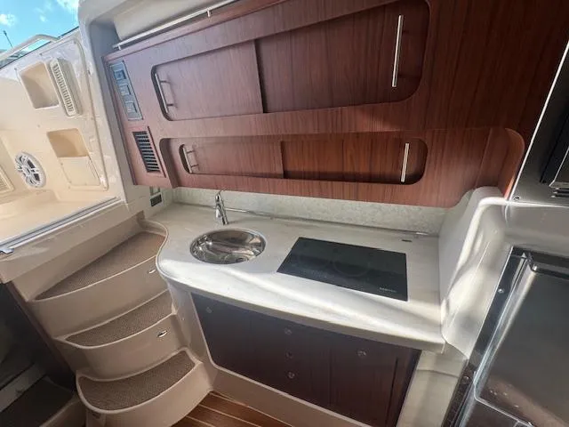  Yacht Photos Pics 2021 Grady-White Express 370 boat interior with kitchenette and wooden cabinetry.