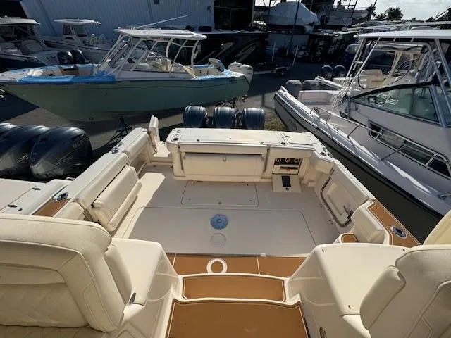  Yacht Photos Pics 2021 Grady-White Express 370 boat interior with seating and controls, docked among other boats.