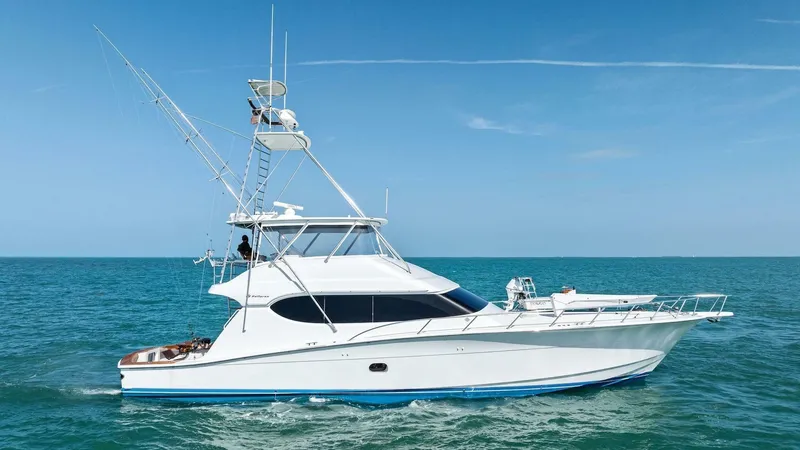 Big Game Yacht Photos Pics 2006 Hatteras 68 Convertible yacht cruising on open sea under clear blue sky.