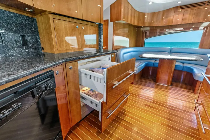 Big Game Yacht Photos Pics Luxurious 2006 Hatteras 68 Convertible yacht interior with wood cabinetry and blue seating.