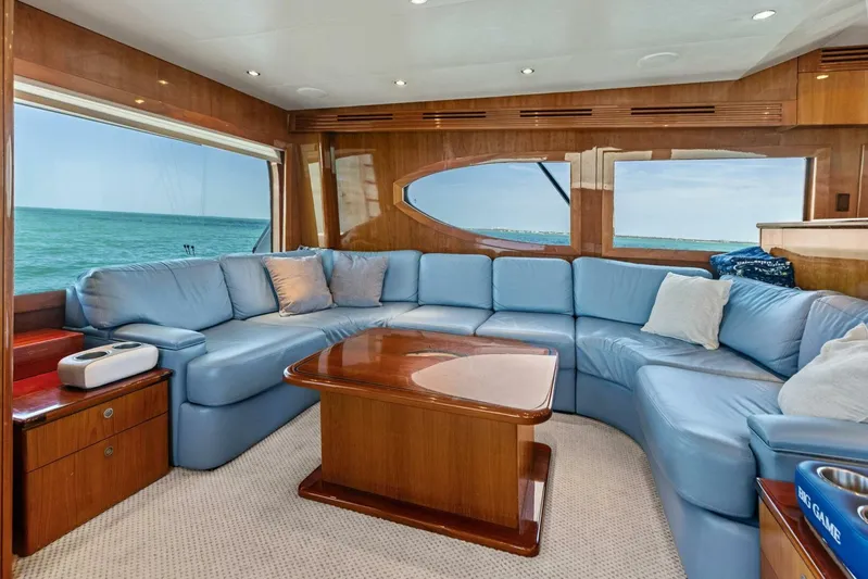 Big Game Yacht Photos Pics Luxurious interior of 2006 Hatteras 68 Convertible yacht with blue seating and ocean view.
