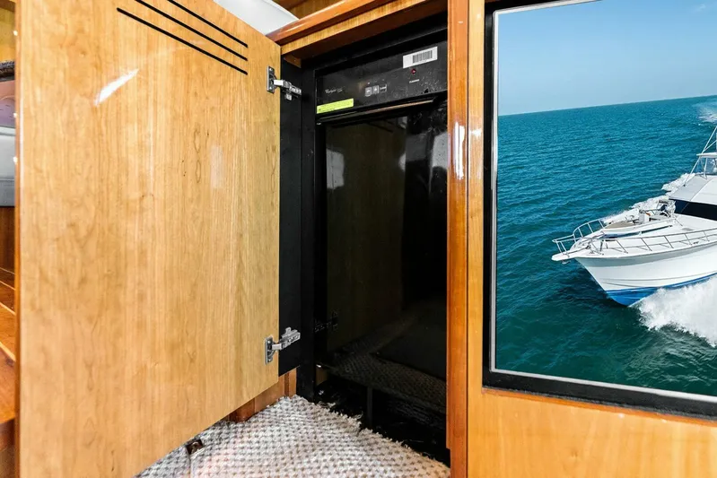 Big Game Yacht Photos Pics Open cabinet on 2006 Hatteras 68 Convertible yacht with ocean view.