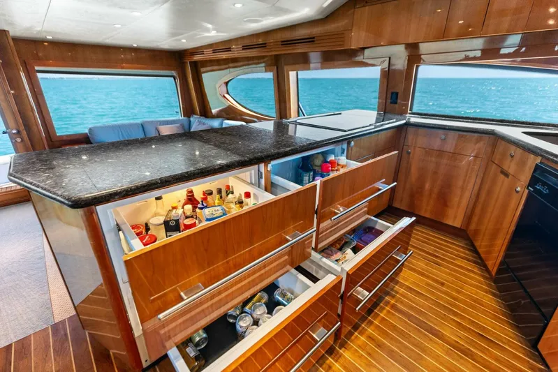Big Game Yacht Photos Pics Luxurious 2006 Hatteras 68 Convertible yacht interior with open kitchen drawers and ocean view.