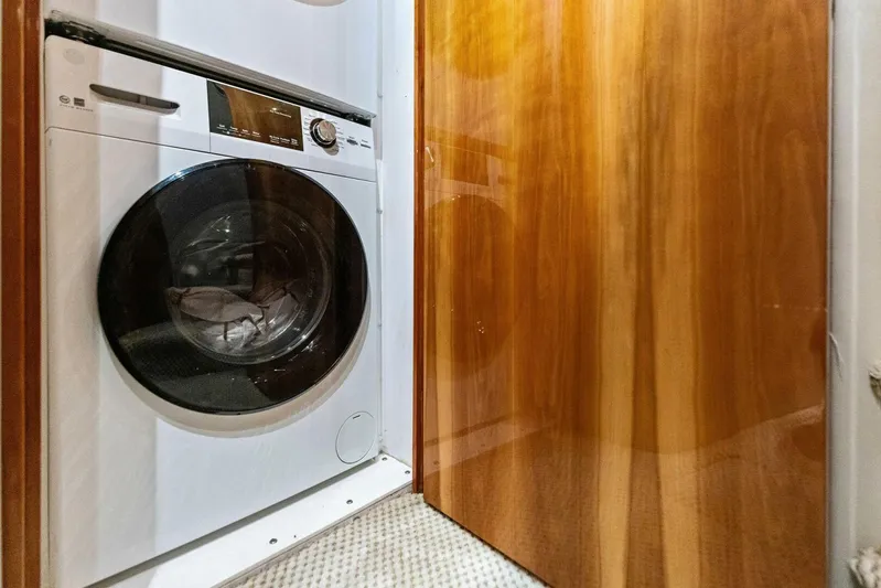 Big Game Yacht Photos Pics Laundry area with a modern washing machine inside a 2006 Hatteras 68 Convertible yacht.
