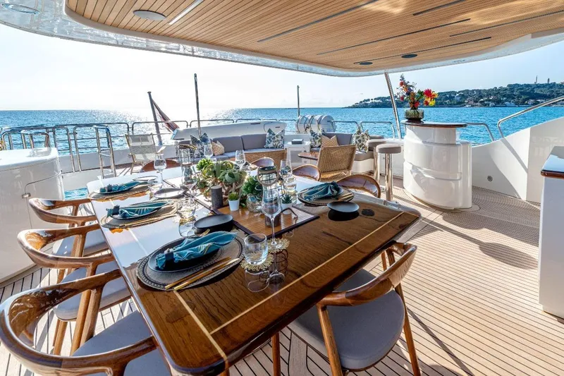 New Star Yacht Photos Pics Luxurious dining area on a 2002 Benetti Tradition 100 yacht, overlooking serene ocean views.