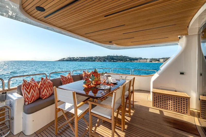 New Star Yacht Photos Pics Luxurious Benetti Tradition 100 yacht deck with dining area, ocean view, and vibrant cushions, 2002 model.