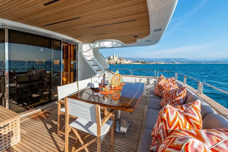 New Star Yacht Photos Pics Luxurious Benetti Tradition 100 yacht deck with dining area, vibrant cushions, and ocean view, 2002 model.