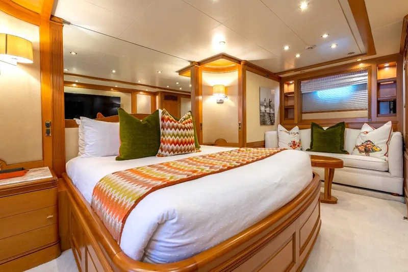 New Star Yacht Photos Pics Luxurious bedroom interior on 2002 Benetti Tradition 100 yacht, featuring elegant decor and cozy seating.