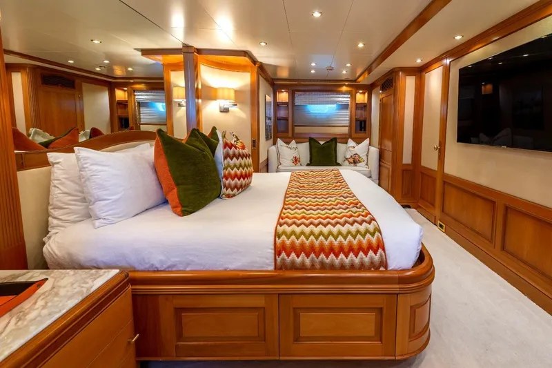 New Star Yacht Photos Pics Luxurious bedroom interior on 2002 Benetti Tradition 100 yacht, featuring elegant wood finishes and vibrant decor.
