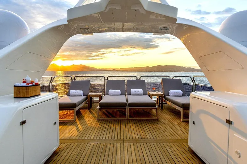 New Star Yacht Photos Pics Luxurious Benetti Tradition 100 yacht deck with sun loungers at sunset, 2002 model.