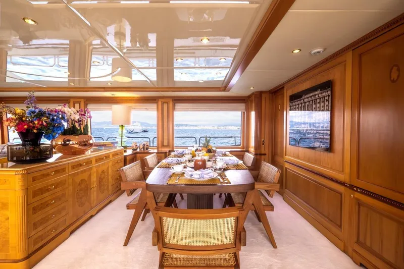 New Star Yacht Photos Pics Luxurious dining area on 2002 Benetti Tradition 100 yacht with elegant wood interior.