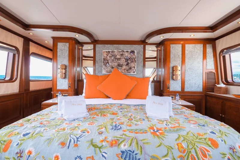 New Star Yacht Photos Pics Luxurious bedroom interior on 2002 Benetti Tradition 100 yacht with floral bedding and ocean view.