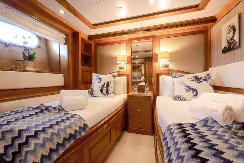 New Star Yacht Photos Pics Luxurious twin cabin on 2002 Benetti Tradition 100 yacht, featuring elegant decor and cozy bedding.