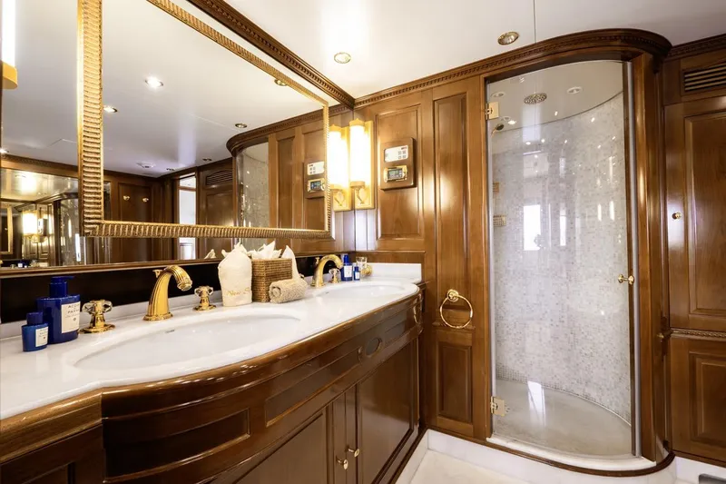 New Star Yacht Photos Pics Luxurious bathroom in 2002 Benetti Tradition 100 yacht with elegant wood finishes and gold fixtures.