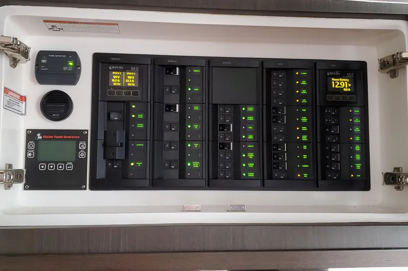 Her Salt Bouys Yacht Photos Pics Electrical control panel of a 2019 Intrepid 475 Sport Yacht, featuring illuminated switches and displays.