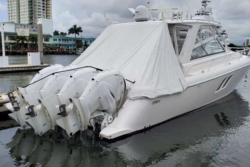 Her Salt Bouys Yacht Photos Pics 2019 Intrepid 475 Sport Yacht docked with covered engines, in a marina setting.