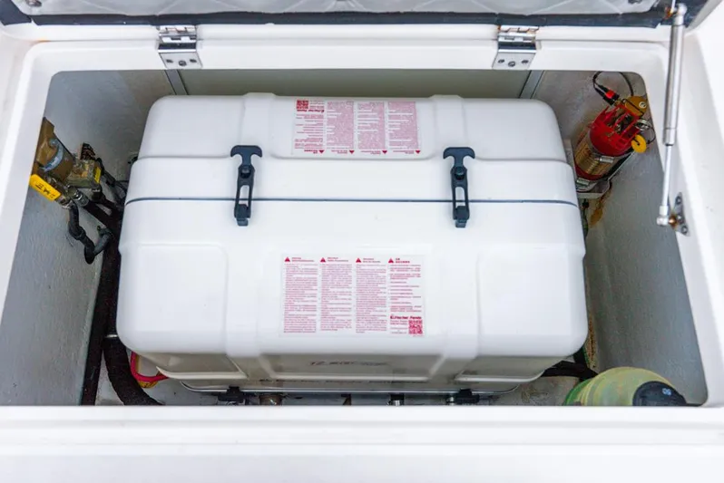 Her Salt Bouys Yacht Photos Pics 2019 Intrepid 475 Sport Yacht storage compartment with safety equipment and fire extinguisher.