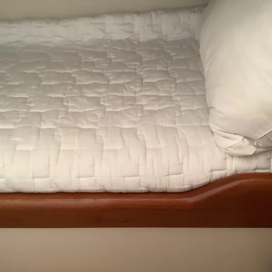 Lauralea Yacht Photos Pics White quilted bed on 2006 Cabo 35 Flybridge Sportfisher boat, featuring wooden trim.