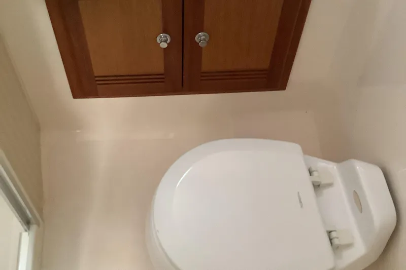 Lauralea Yacht Photos Pics Bathroom interior of 2006 Cabo 35 Flybridge Sportfisher with wooden cabinet and toilet.