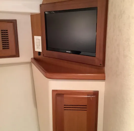 Lauralea Yacht Photos Pics 2006 Cabo 35 Flybridge Sportfisher interior with wall-mounted TV and wooden cabinetry.