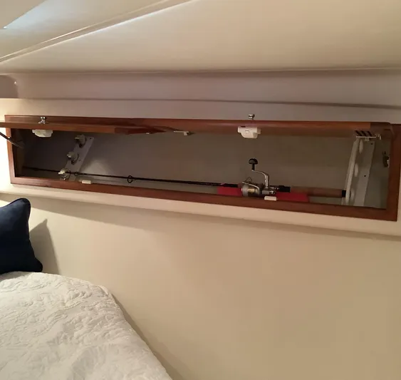 Lauralea Yacht Photos Pics Fishing rod storage in 2006 Cabo 35 Flybridge Sportfisher cabin, featuring wooden compartment.