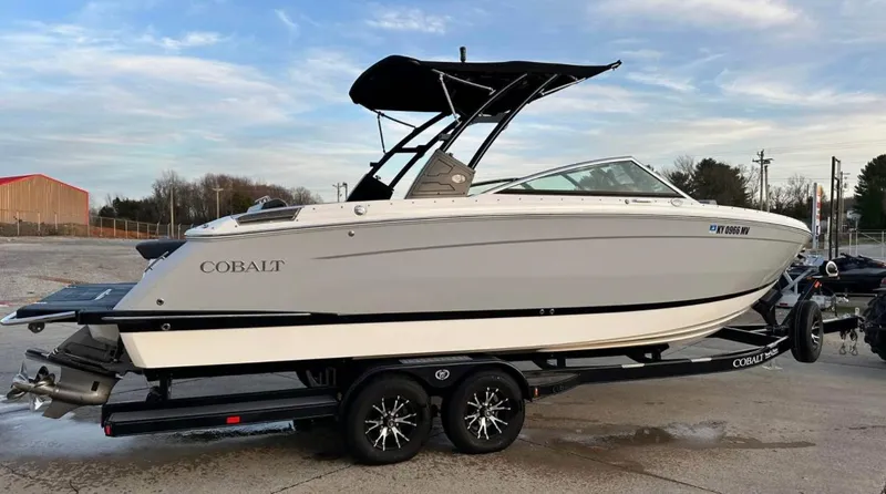  Yacht Photos Pics 2022 Cobalt R8 boat on trailer, sleek design, black canopy, parked outdoors.