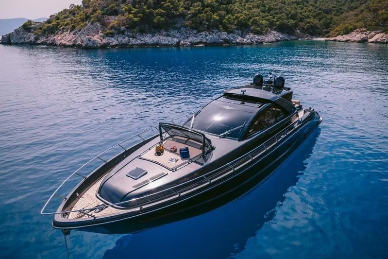  Yacht Photos Pics Luxurious 2006 Riva 68 Ego yacht on serene blue waters near a rocky coastline.