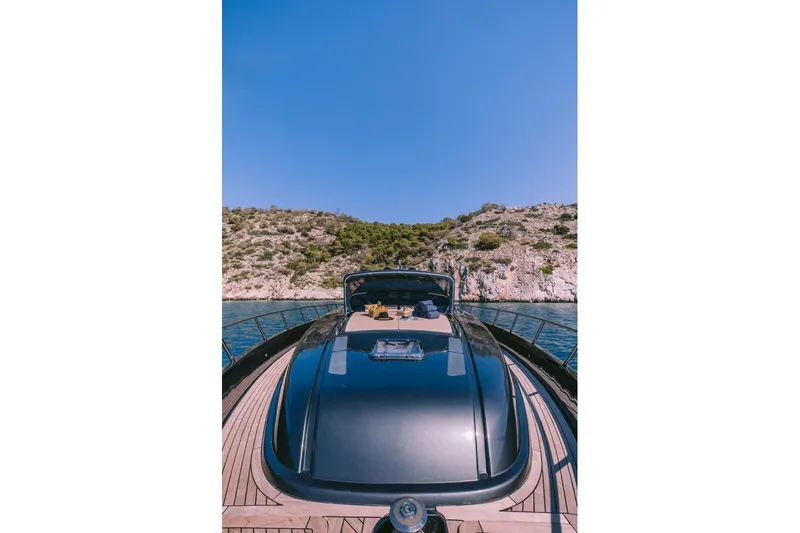  Yacht Photos Pics Luxury 2006 Riva 68 Ego yacht cruising near rocky coastline under clear blue sky.