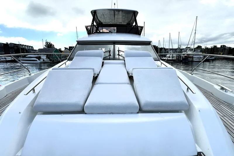 Lady Jane III Yacht Photos Pics Luxurious 2023 Prestige 520 yacht with sun loungers, docked at a marina.