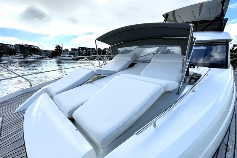 Lady Jane III Yacht Photos Pics Luxurious 2023 Prestige 520 yacht with sun loungers on deck, docked by the waterfront.