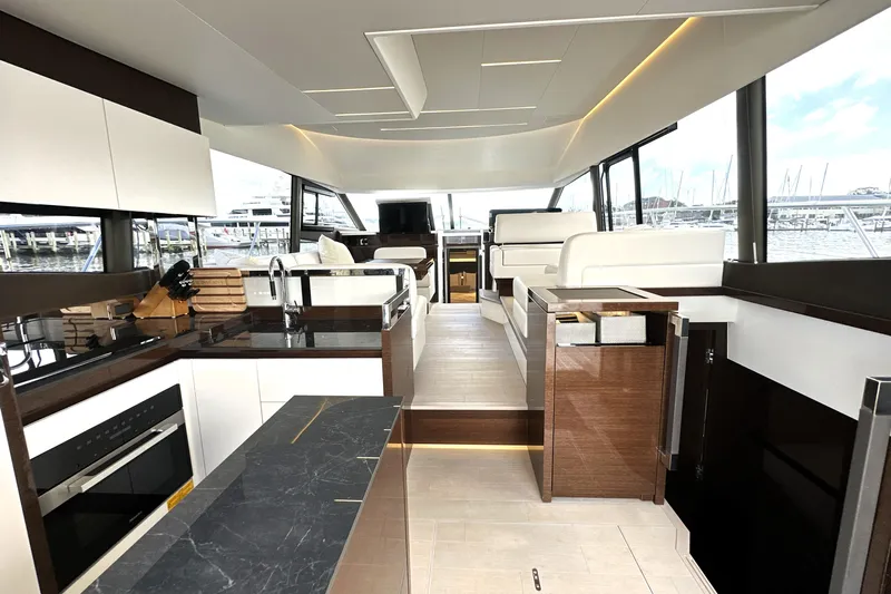 Lady Jane III Yacht Photos Pics Luxurious interior of 2023 Prestige 520 yacht with modern kitchen and seating area.