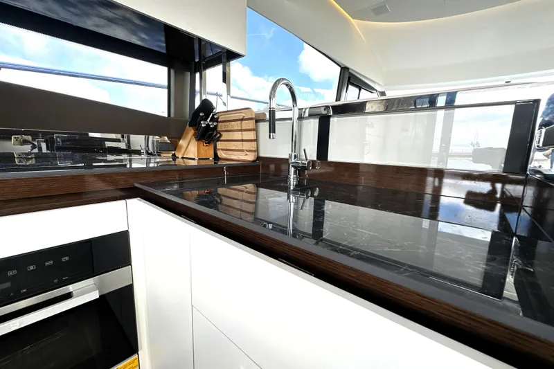 Lady Jane III Yacht Photos Pics Modern kitchen interior on 2023 Prestige 520 yacht with sleek countertops and stainless steel fixtures.