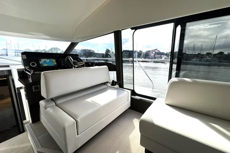 Lady Jane III Yacht Photos Pics Interior of 2023 Prestige 520 yacht with modern helm and seating, overlooking marina.