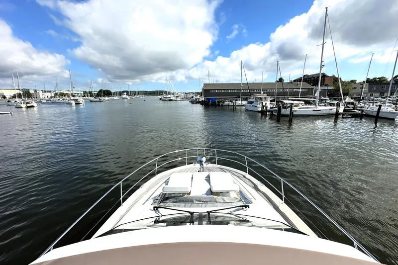 Lady Jane III Yacht Photos Pics Prestige 520 yacht in marina, 2023 model, surrounded by sailboats under a partly cloudy sky.