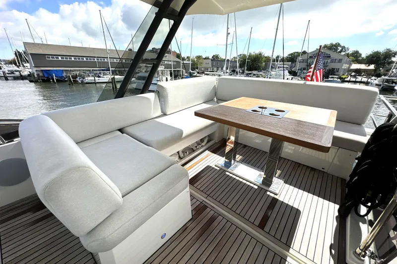 Lady Jane III Yacht Photos Pics Luxurious seating area on 2023 Prestige 520 yacht with wooden table and marina view.